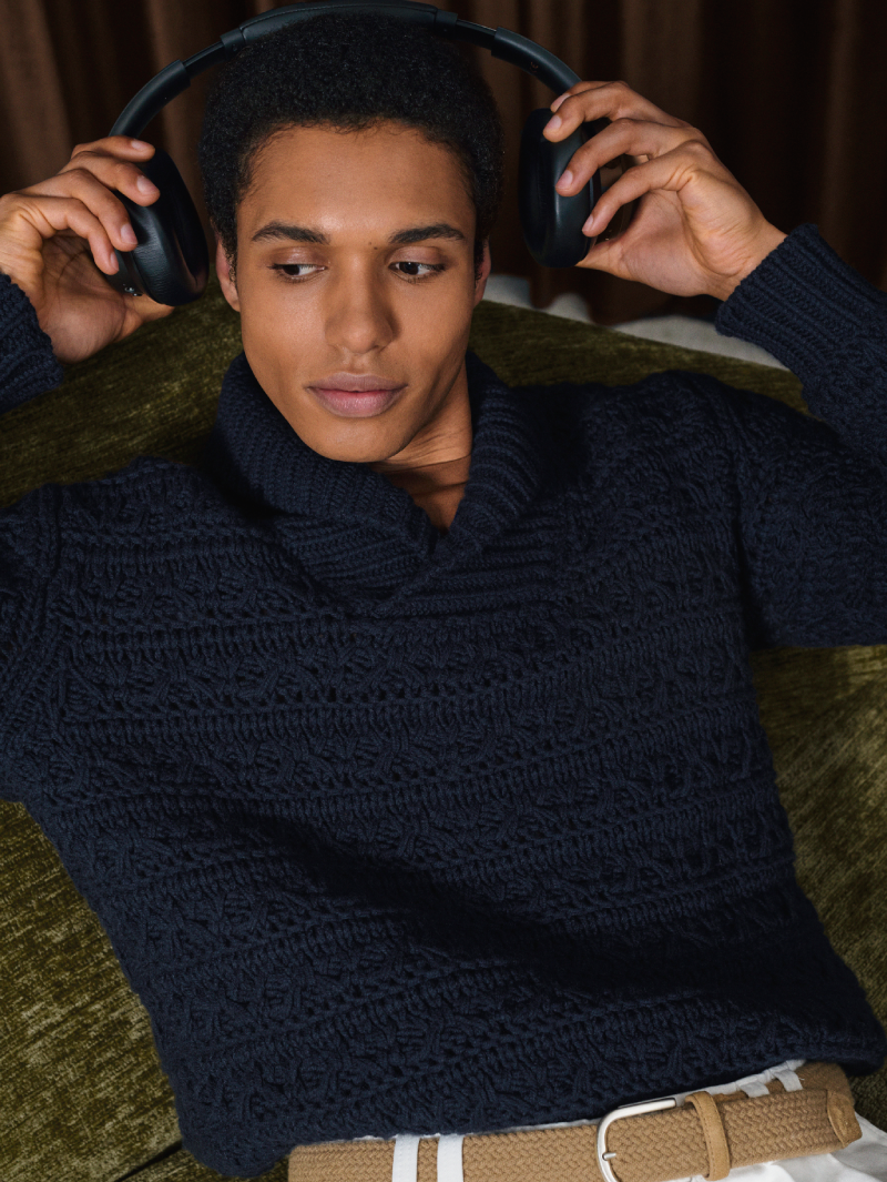 Canali navy blue textured knit sweater with a shawl collar, styled with ivory trousers and a woven belt, worn in an elegant indoor setting.
